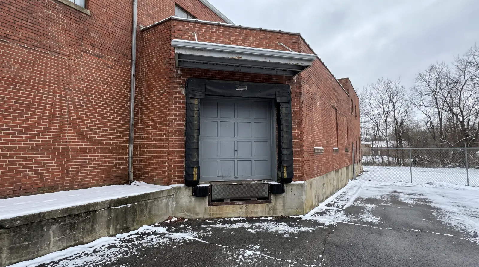 Loading dock door with a compression dock seal around the opening