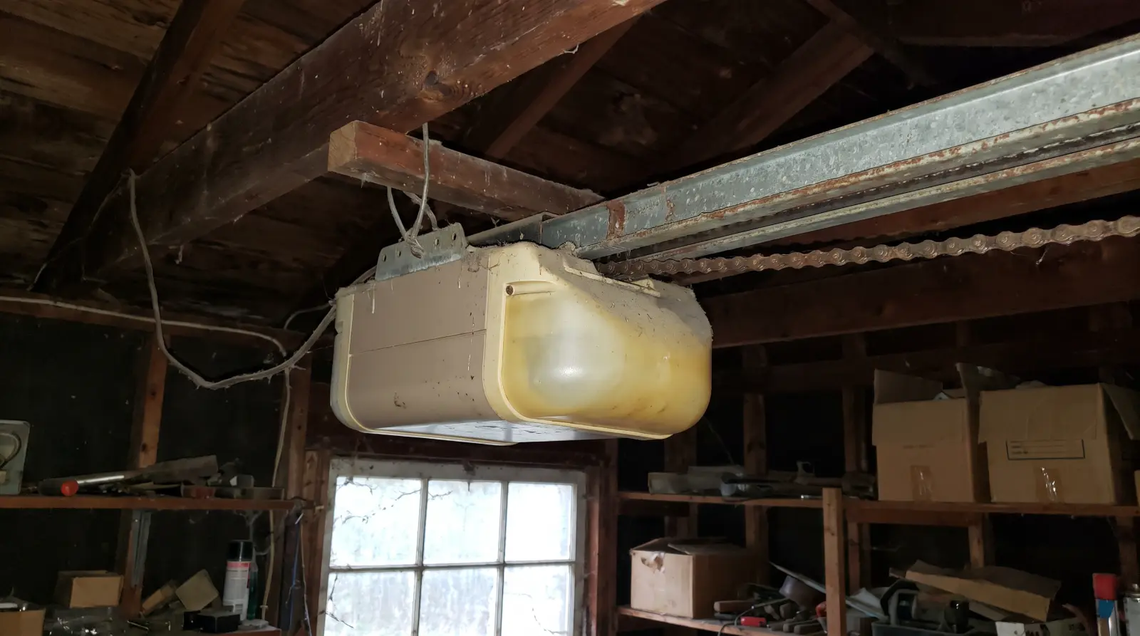 Older chain drive garage door opener mounted to the garage ceiling